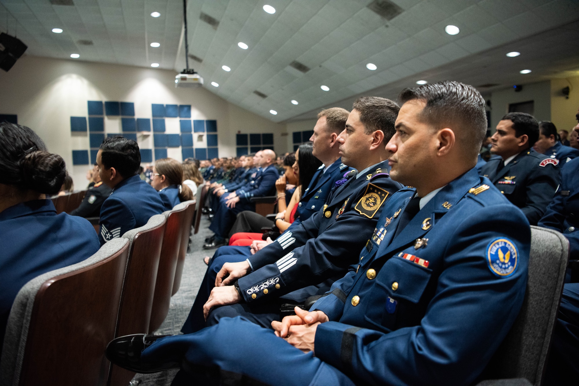 Partner Nation Guest Instructor Capt. Tebbit Brown of Fuerza Aerea Honduras, watches the stage during the Inter-American Air Forces Academy graduation ceremony at Joint Base San Antonio-Lackland, Texas, Dec. 7, 2022. More than 150 international military students from 12 partner nations across Latin America and the USAF graduated during the last training cycle of 2022. (U.S. Air Force photo by Vanessa R. Adame)