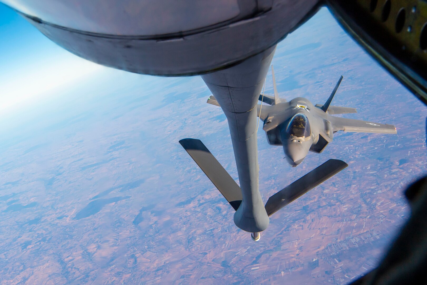 A jet pulls near another aircraft to refuel.