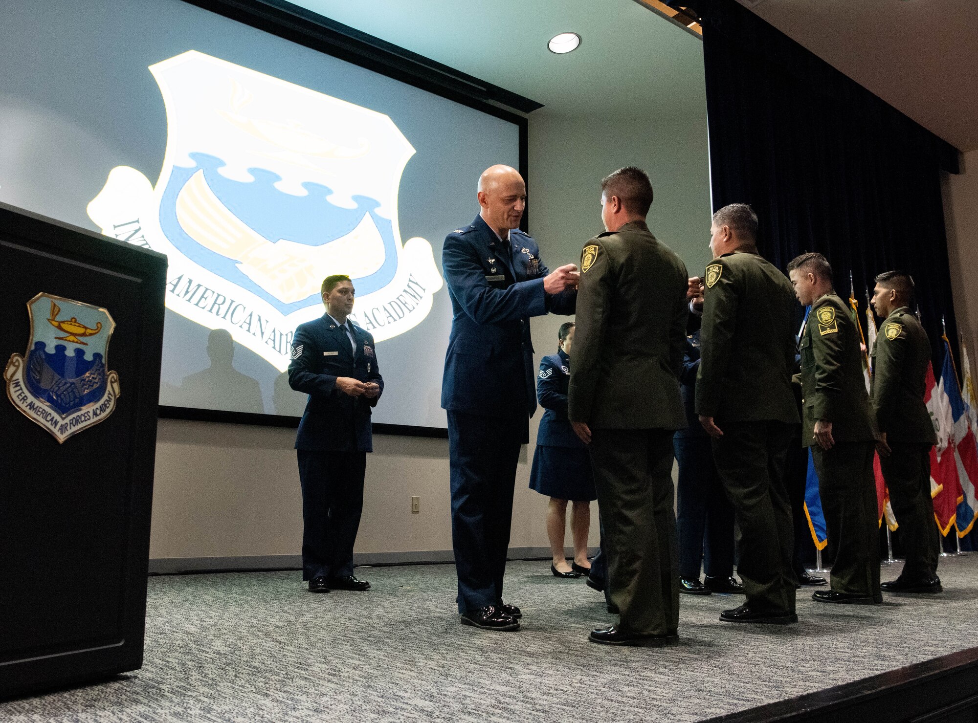 Col. José Jiménez, Jr., commandant of the Inter-American Air Forces Academy, pins an international military student with the IAAFA wings during the Academy’s graduation ceremony at Joint Base San Antonio-Lackland, Texas, Dec. 7, 2022. More than 150 international military students from 12 partner nations across Latin America and the USAF graduated during the last training cycle of 2022. (U.S. Air Force photo by Vanessa R. Adame)
