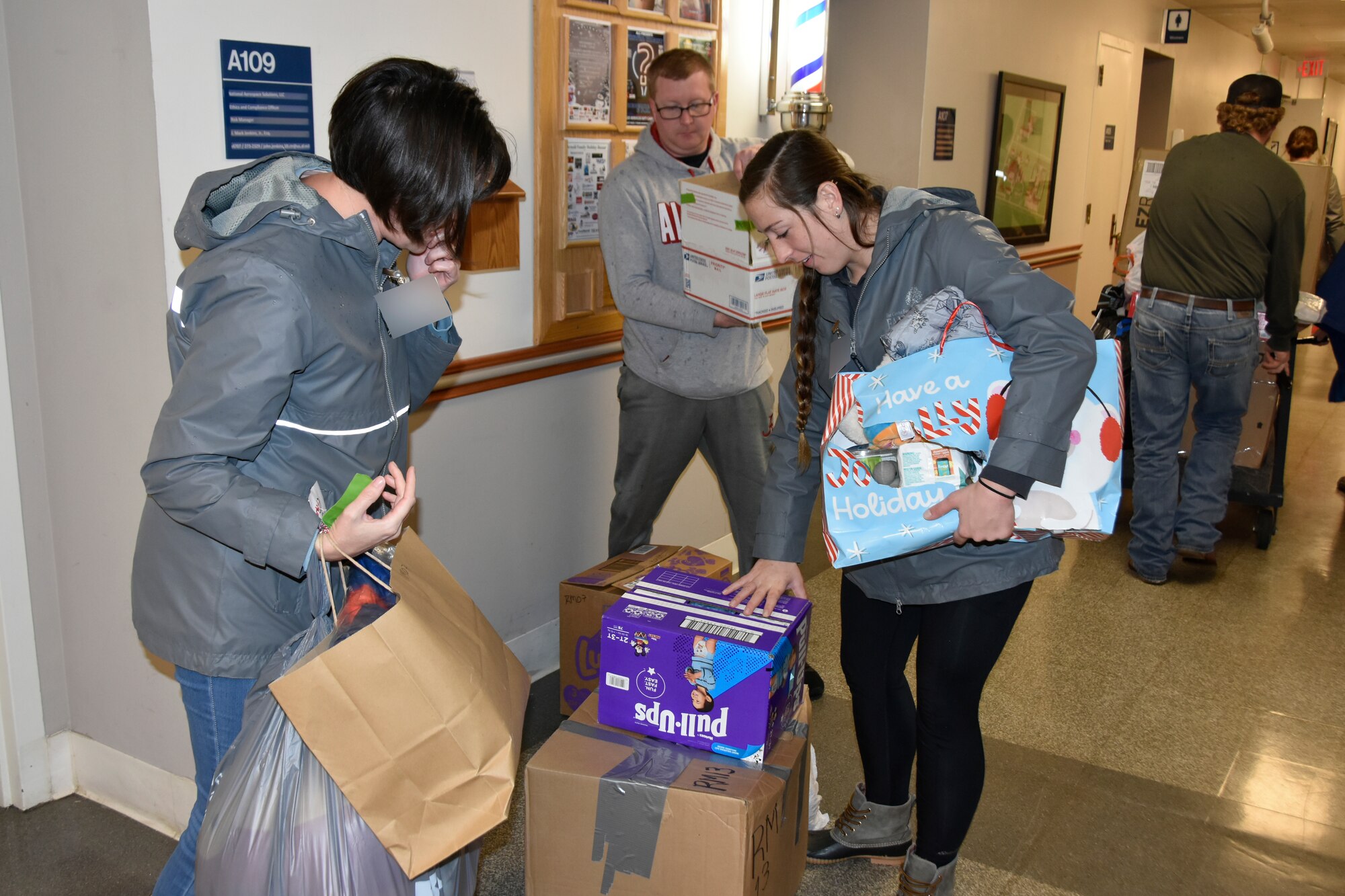 Heather Ricardson, left, and Hayley Pomarico, right, from the Center for Family Development in Shelbyville collect gifts purchased by Arnold Air Force Base personnel during the 2022 Arnold Engineering Development Complex Gift Sponsor toy drive, previously known as the AEDC Angel Tree, Dec. 14, 2022, at Arnold AFB, Tennessee. Members of the Arnold workforce sponsored more than 150 area children this year to provide them with gifts for Christmas. (U.S. Air Force photo by Bradley Hicks) (This image was altered by obscuring badges for security purposes.)