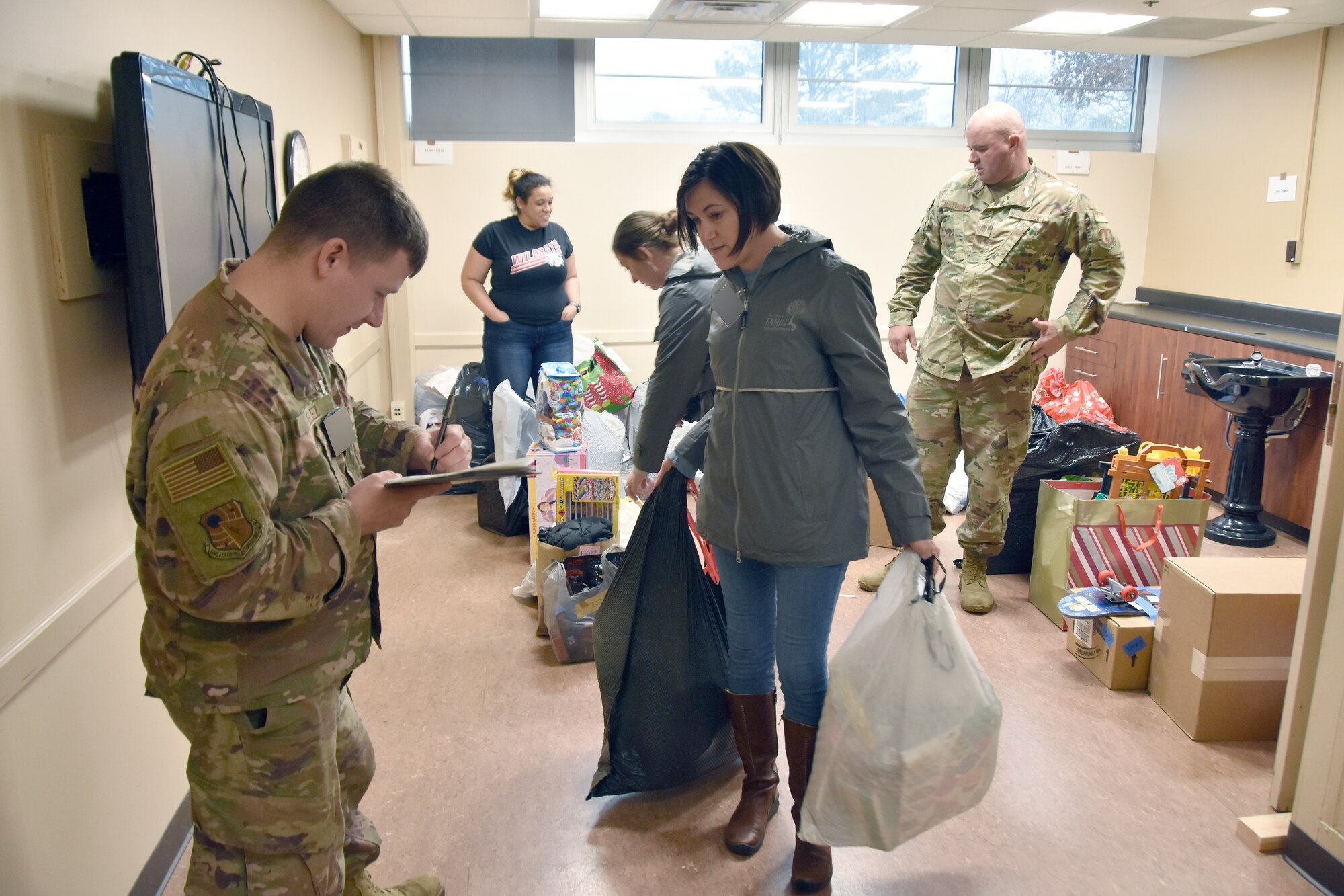 Master Sgt. Anthony Velez, Arnold Engineering Development Complex senior munitions inspector, left, checks off the gifts collected and readied for transport by Heather Richards from the Center for Family Development in Shelbyville, Dec. 14, 2022, at Arnold Air Force Base, Tennessee. Center staff and volunteers visited Arnold AFB to collect gifts purchased by base personnel during the 2022 AEDC Gift Sponsor toy drive, previously known as the AEDC Angel Tree, Dec. 14, 2022. Members of the Arnold workforce sponsored more than 150 area children this year to provide them with gifts for Christmas. (U.S. Air Force photo by Bradley Hicks) (This image was altered by obscuring badges for security purposes.)