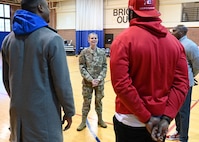 U.S. Air Force Col. Catherine "Cat" Logan, Joint Base Anacostia-Bolling and 11th Wing commander, speaks with members of the Extreme Football League D.C. Defenders team on JBAB, Washington, D.C., at the JBAB Fitness Center on Dec. 16, 2022. Engagements with sports teams in the greater D.C. area are one of many ways JBAB connects with the surrounding communities. Strong community partnerships foster trust and support, bridging the military-civilian gap in experience and understanding. (U.S. Air Force photo by Tech. Sgt. Kayla White)