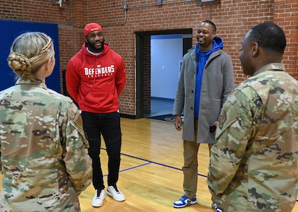 Extreme Football League D.C. Defenders defensive lineman Jesse Aniebonam and team vice president Lance Wesson speak with U.S. Air Force Col. Catherine "Cat" Logan and Command Chief Master Sgt. Clifford Lawton, Joint Base Anacostia-Bolling and 11th Wing commander and command chief, on JBAB, Washington, D.C., at the JBAB Fitness Center on Dec. 16, 2022. Engagements with sports teams in the greater D.C. area are one of the many ways JBAB connects with the surrounding communities. Strong community partnerships foster trust and support, bridging the military-civilian gap in experience and understanding. (U.S. Air Force photo by Tech. Sgt. Kayla White)