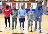U.S. Air Force Col. Catherine "Cat" Logan and Command Chief Master Sgt. Clifford Lawton, Joint Base Anacostia-Bolling and 11th Wing commander and command chief Chief Master Sgt. Clifford Lawton pose for a group photo with members of the Extreme Football League D.C. Defenders team at the JBAB fitness center on Dec. 16, 2022, JBAB, Washington, D.C. Engagements with sports teams in the greater D.C. area are one of many ways JBAB connects with the surrounding communities. Strong community partnerships foster trust and support, bridging the military-civilian gap in experience and understanding. (U.S. Air Force photo by Tech. Sgt. Kayla White)