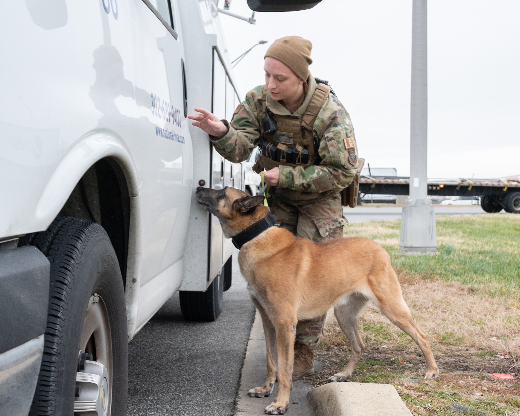 Senior Airman Courtney Burns, 436th Security Forces Squadron military working dog handler, and MWD Zorro inspect delivery vehicles entering the commercial gate on Dover Air Force Base, Delaware, Dec. 22, 2022. Team Dover Airmen continue to provide unrivaled installation support, rapid global airlift and combat ready Airmen 24 hours of the day, 365 days of the year. (U.S. Air Force photo by Mauricio Campino)