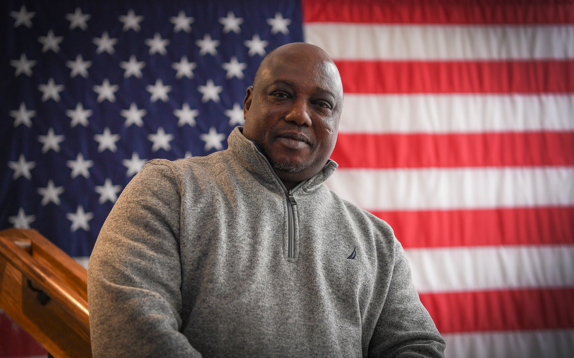 Ernest stands in front of american flag on staircase