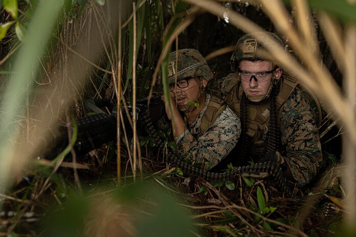U.S. Marine Corps Cpl. Samuel Llamas, a combat engineer, and Lance Cpl. Ivey Logan, a landing support specialist, both with 3rd Landing Support Battalion, Combat Logistics Regiment 3, 3rd Marine Logistics Group, set up an ambush with an M240B medium machine gun for a simulated convoy during exercise Winter Workhorse, at Central Training Area, Camp Hansen, Okinawa, Japan, Dec. 6, 2022. Winter Workhorse is an annual exercise for CLR-3 to train to carry out mission essential tasks in forward-deployed, austere environments. (U.S. Marine Corps photo by Lance Cpl. Weston Brown)
