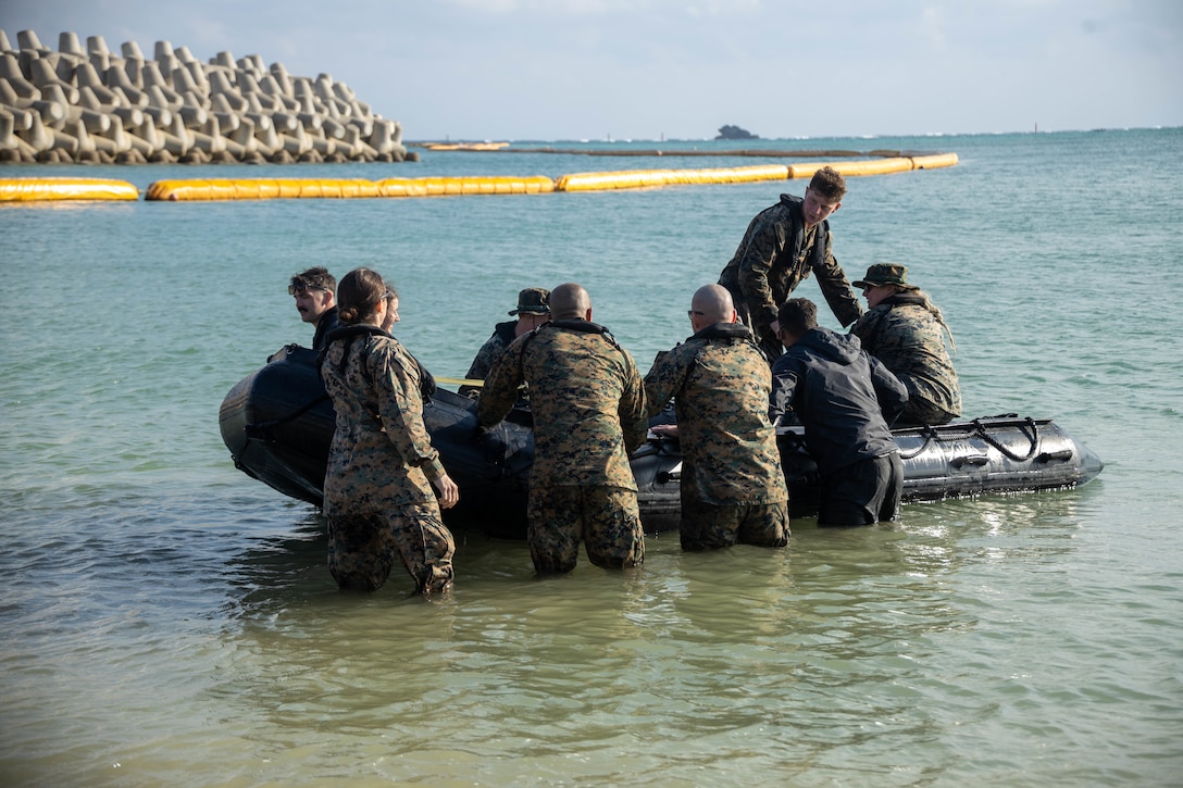U.S. Marines with 3rd Transportation Battalion, Combat Logistics Regiment 3, 3rd Marine Logistics Group, push a combat rubber raiding craft off from the shore on Recon Beach, Camp Schwab, Okinawa, Japan, December 7, 2022. Marines with 3rd Transportation Battalion, Combat Logistics Regiment 3, 3rd Marine Logistics Group, and Marines with 3rd Recon fostered skills maneuvering rubber raiding craft with added weight to prepare for future operations and exercises. (U.S. Marine Corps photo by Lance Cpl. Federico Marquez)
