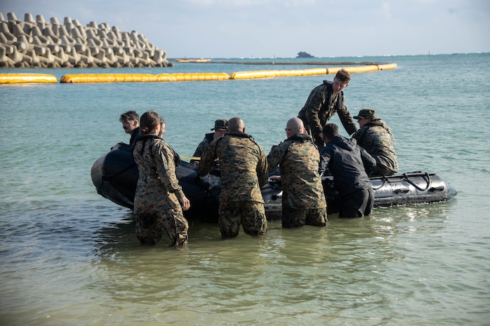 U.S. Marines with 3rd Transportation Battalion, Combat Logistics Regiment 3, 3rd Marine Logistics Group, push a combat rubber raiding craft off from the shore on Recon Beach, Camp Schwab, Okinawa, Japan, December 7, 2022. Marines with 3rd Transportation Battalion, Combat Logistics Regiment 3, 3rd Marine Logistics Group, and Marines with 3rd Recon fostered skills maneuvering rubber raiding craft with added weight to prepare for future operations and exercises. (U.S. Marine Corps photo by Lance Cpl. Federico Marquez)