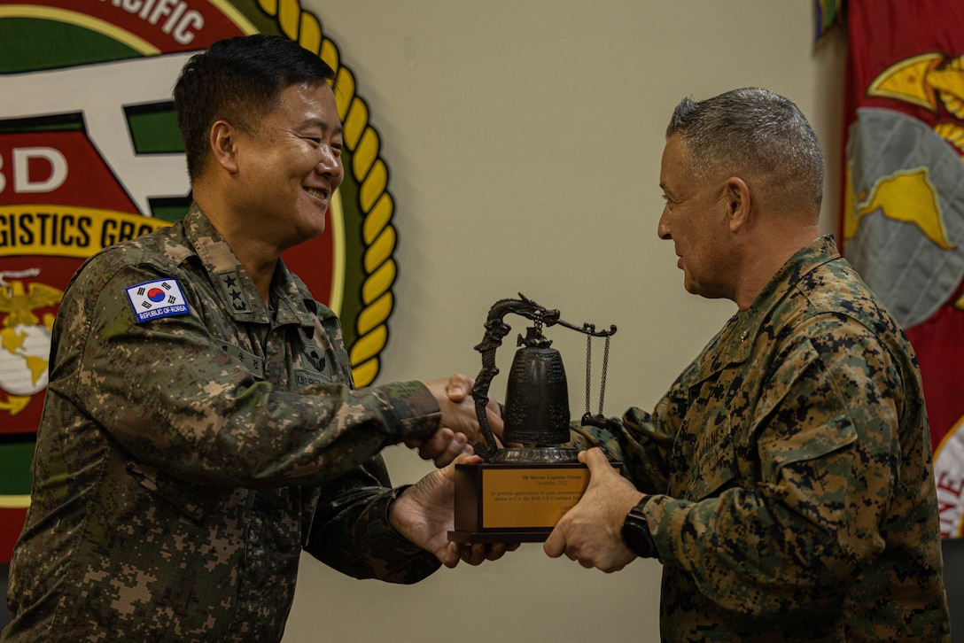 U.S. Marine Corps Brig. Gen. Adam Chalkley, right, the commanding general of 3rd Marine Logistics Group, and Maj. Gen. Soon Choi, Commander of the 31st Infantry Division, Republic of Korea, exchange gifts during a key leader engagement at Camp Kinser, Okinawa, Japan, Dec. 15, 2022. 3rd MLG, based out of Okinawa, Japan, is a forward-deployed combat unit that serves as III Marine Expeditionary Force’s comprehensive logistics and combat service support backbone for operations throughout the Indo-Pacific area of responsibility. (U.S. Marine Corps photo by Lance Cpl. Weston Brown)