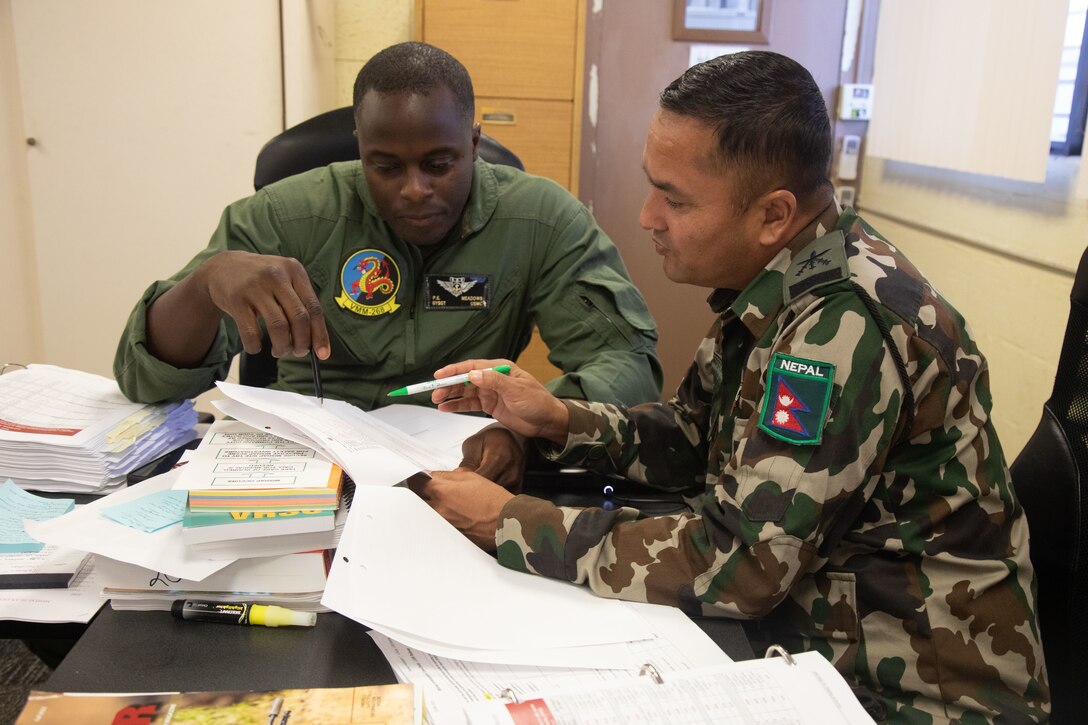 U.S. Marine Corps Gunnery Sgt. Prentice Meadows, left, a tiltrotor crew chief with Marine Medium Tiltrotor Squadron 268, Marine Aircraft Group 24, studies with a Nepalese officer during the Global Peace Operations Initiative Operational Risk Management course, Marine Corps Base Hawaii, Dec. 15, 2022. The purpose of the course was to highlight and amplify risk management training that enhances future “train the trainer” opportunities. (U.S. Marine Corps photo by Lance Cpl. Chandler Stacy)