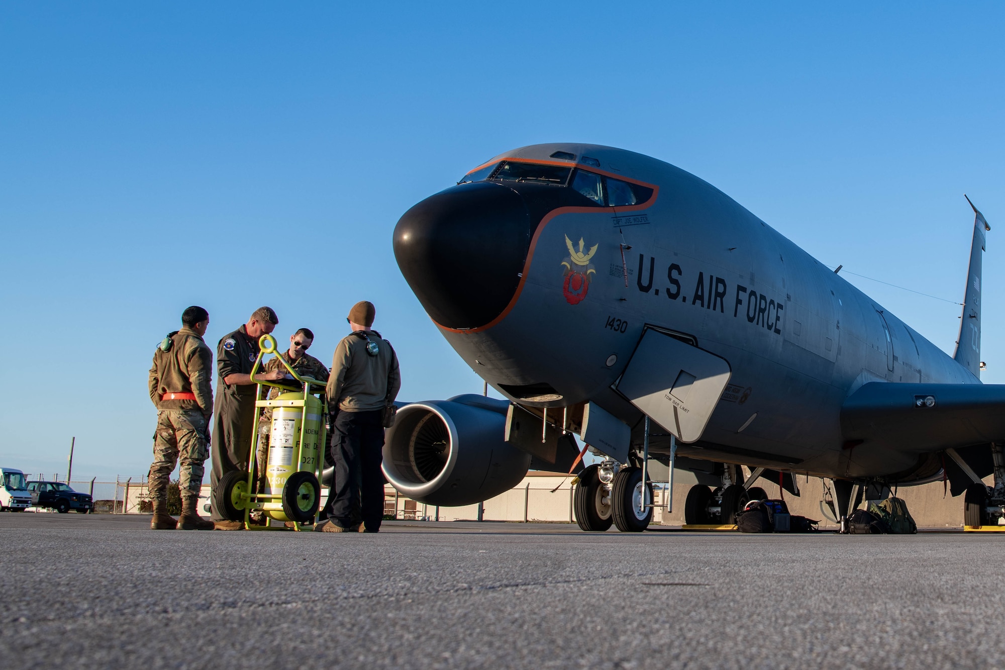 Airmen review materials in front of an aircraft.