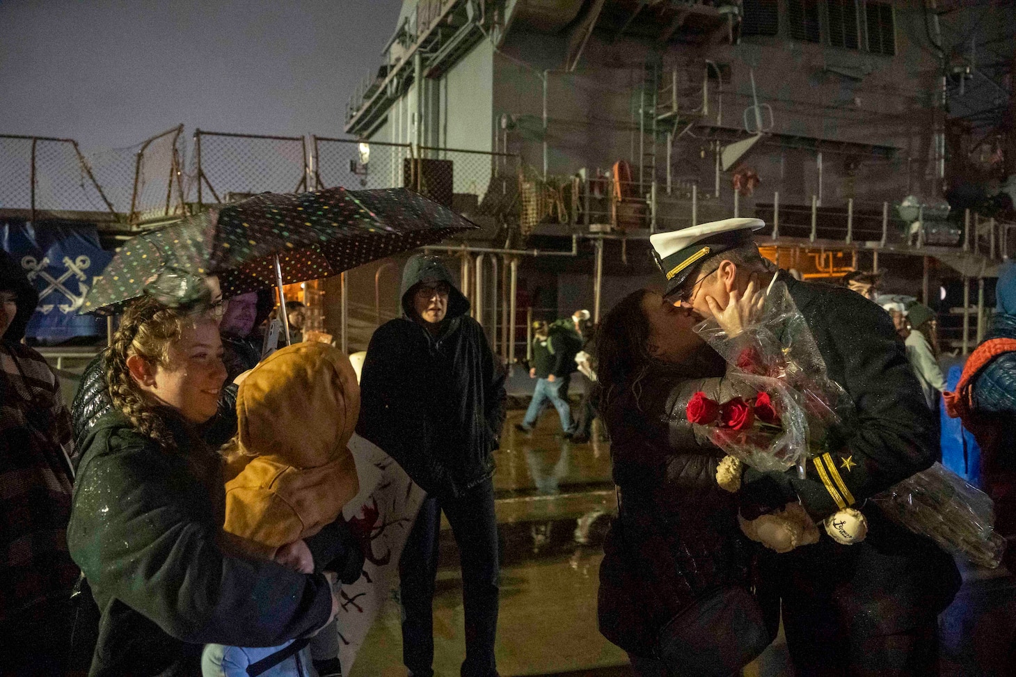 A Sailor assigned to the Arleigh Burke-class guided-missile destroyer USS Forrest Sherman (DDG 98) embraces his partner following the ship's  return to Naval Station Norfolk, Dec 22.