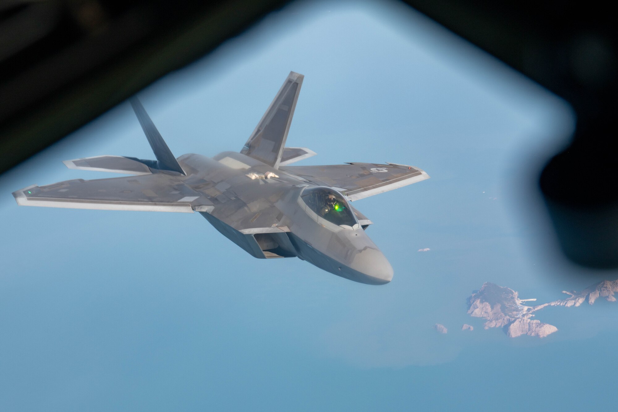 An aircraft flies over water.