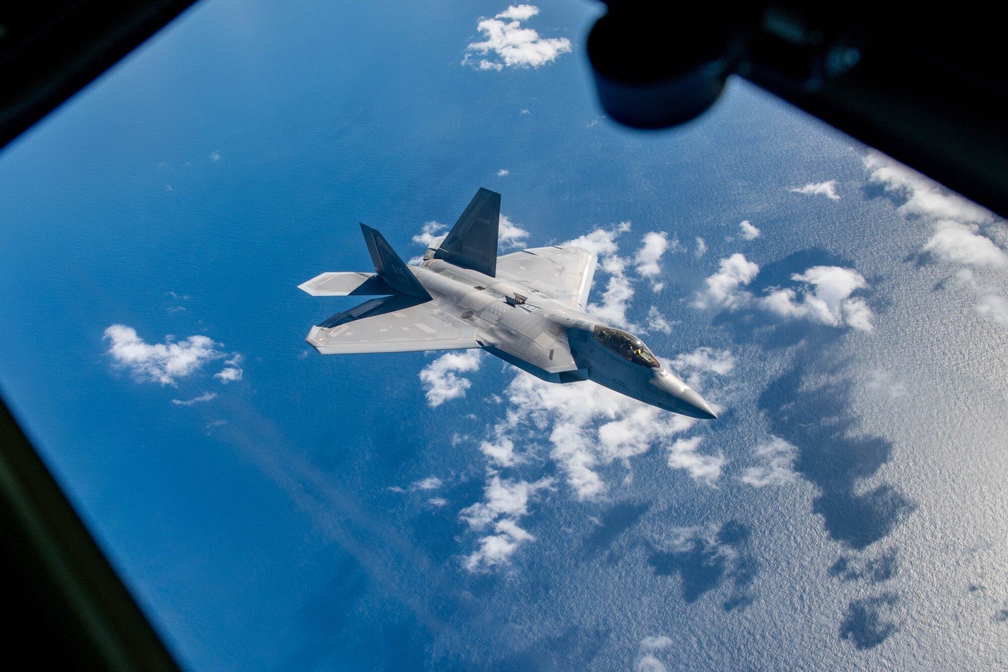 An aircraft flies over the ocean.