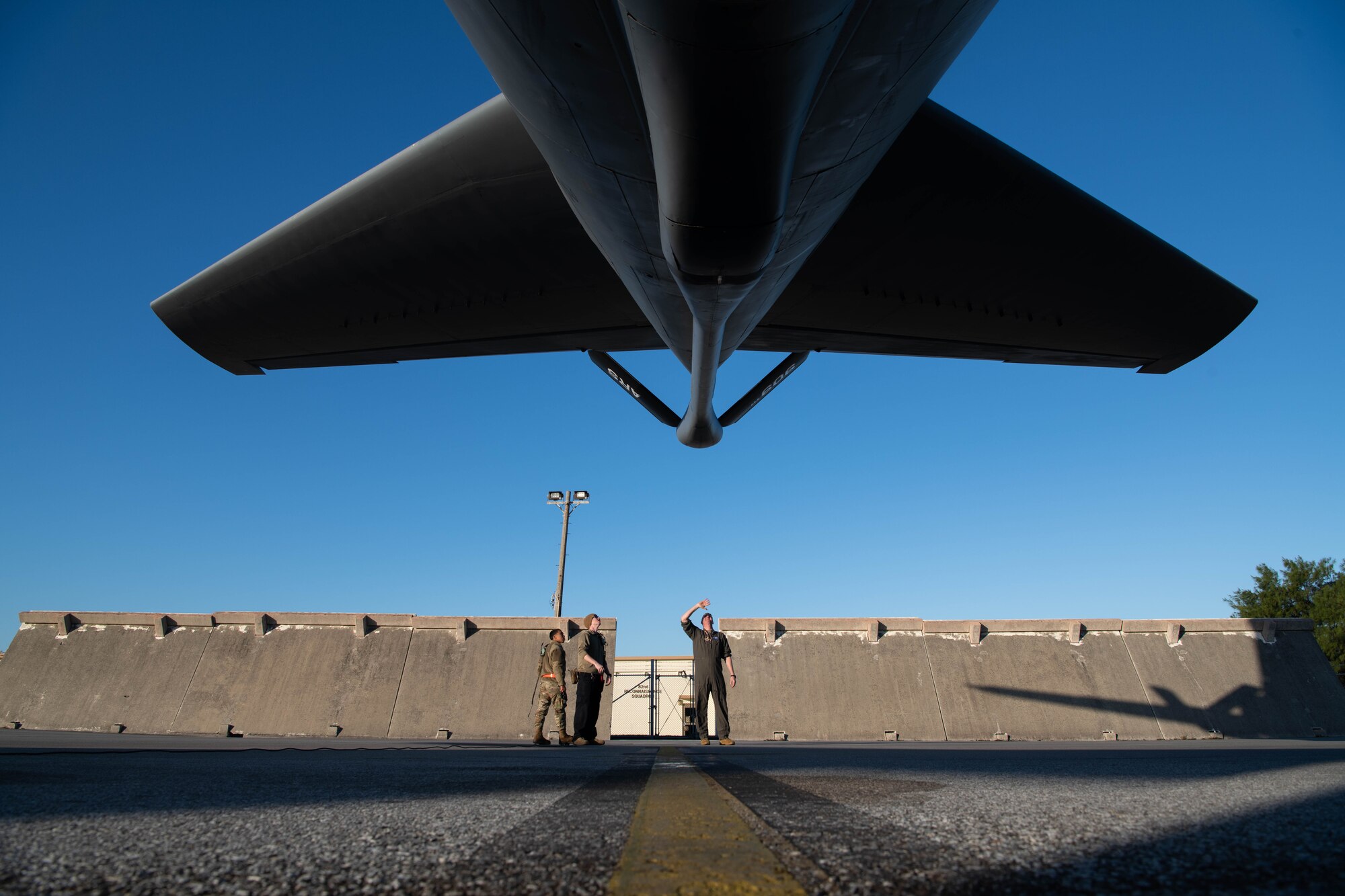 Airmen walk around an aircraft.