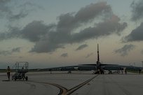 A photo Airmen pushing a maintenance stand on the flightline.