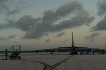 A photo Airmen pushing a maintenance stand on the flightline.