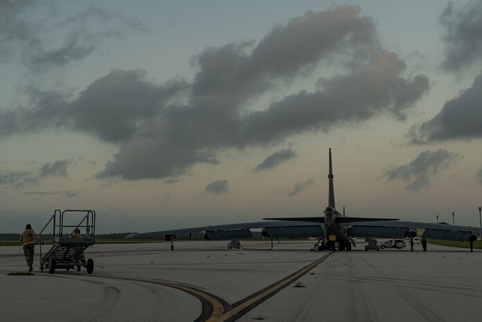 A photo Airmen pushing a maintenance stand on the flightline.