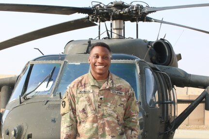 U.S. Army Spc. Stephon Johnson, UH-60 helicopter mechanic for Delta Company, 3rd Battalion, 142nd Aviation Regiment, Assault Helicopter Battalion, attached to the 36th Combat Aviation Brigade, "Task Force Mustang," poses in front of an UH-60 Black Hawk helicopter, at Al Asad Air Base, Iraq, Dec. 10, 2022.