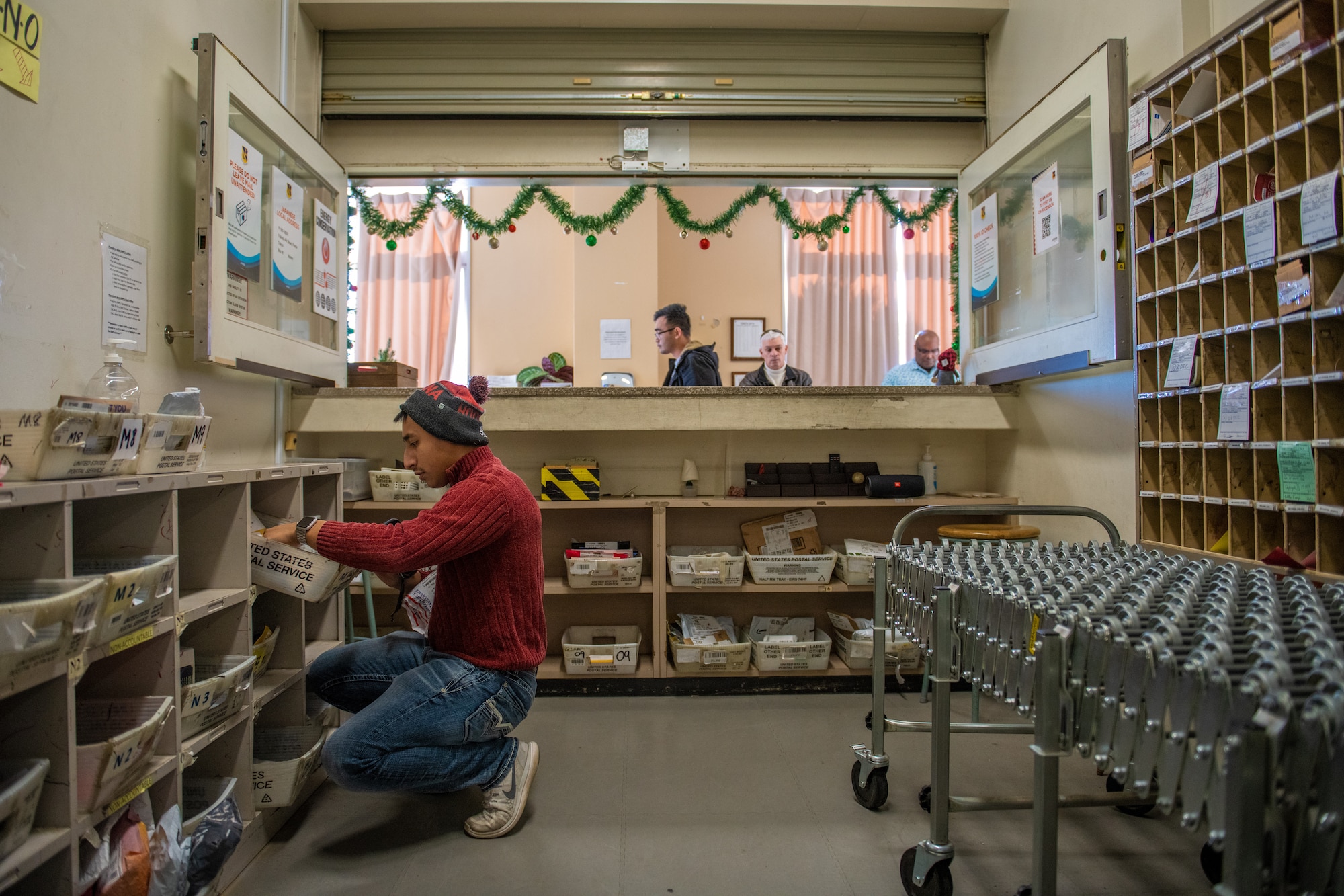 A postal clerk sorts and locates packages