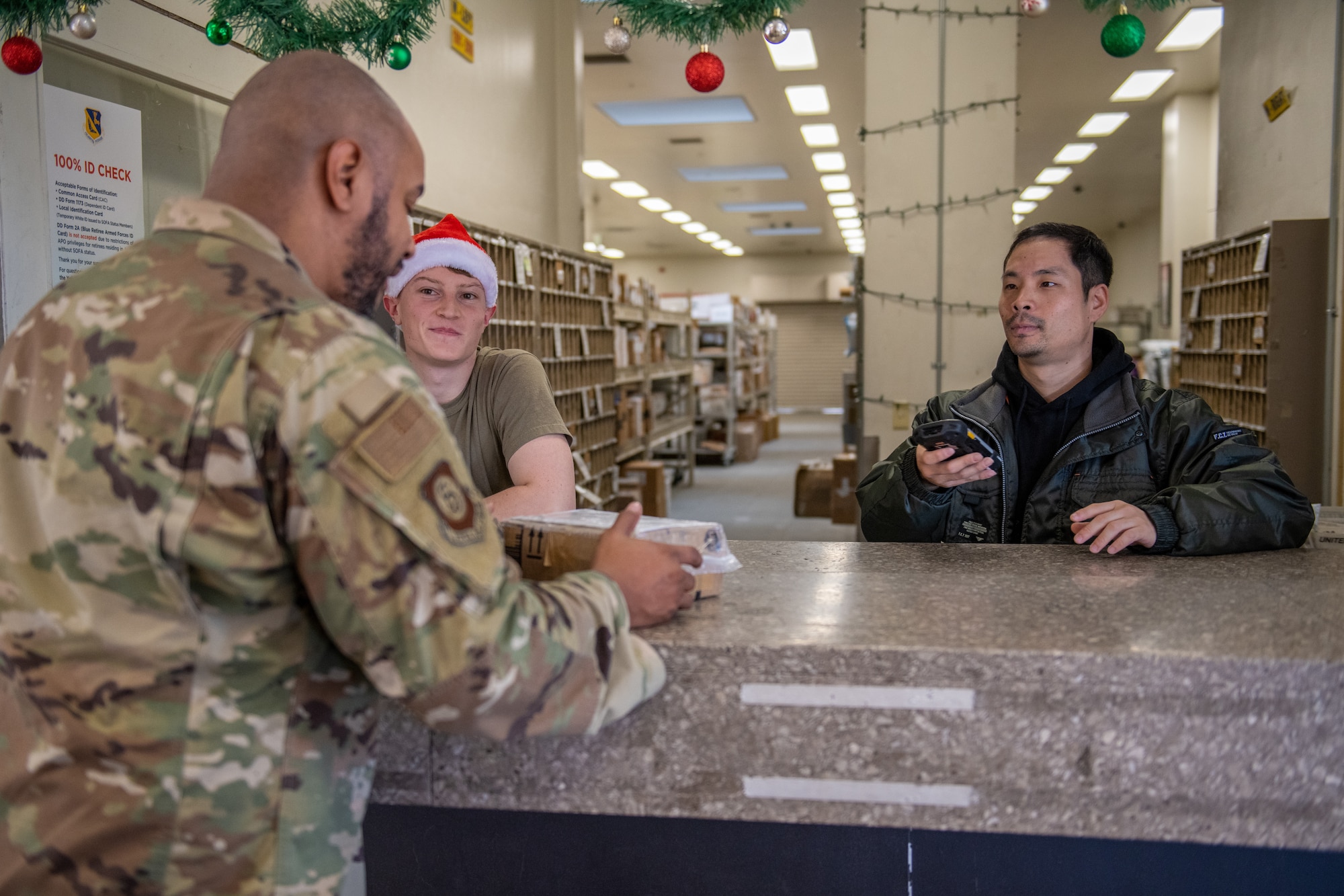 Postal clerks deliver a package to a customer