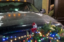 Airman 1st Class Abbigail Feathers, 341st Security Forces Squadron defender, verifies identification cards at the main gate at Malmstrom Air Force Base, Mont., Dec. 20, 2022.  Feathers and other defenders defend the gate of the installation 24/7 and in any weather condition. (U.S. Air Force photo by Elijah Van Zandt)