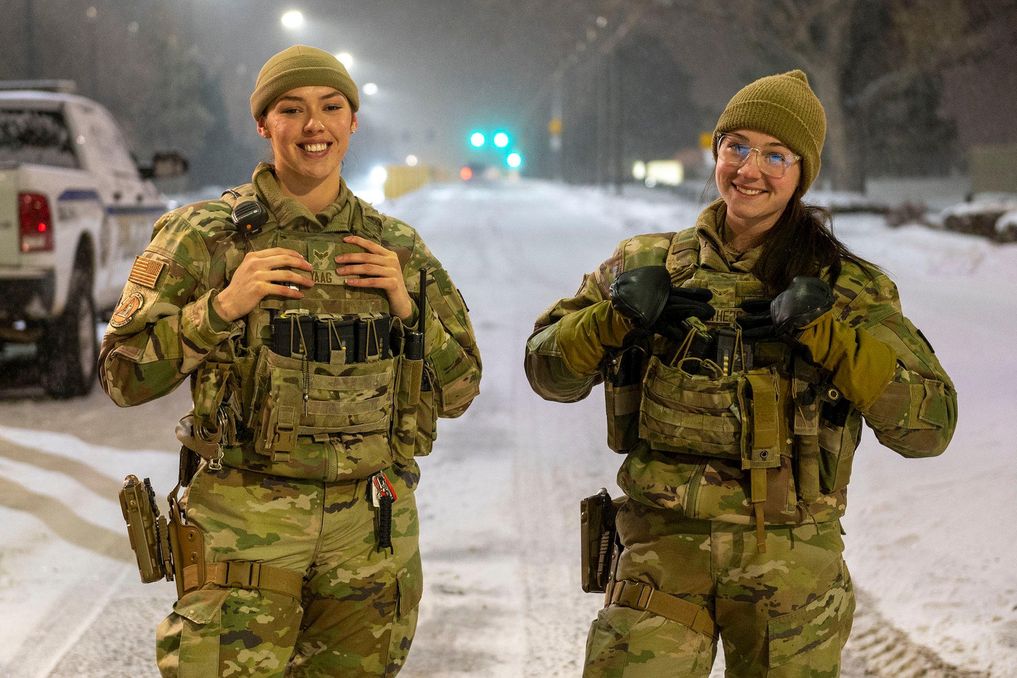 Airman 1st Class Elissa Yaag, left, and Airman 1st Class Abbigail Feathers, 341st Security Forces Squadron defenders, pose for a photo at the main gate of Malmstrom Air Force Base, Dec. 20, 2022. 
Defenders stand guard at the base 24/7 and ensure, in any weather condition, that no unauthorized personnel enter the installation. (U.S. Air Force photo by Airman 1st Class Elijah Van Zandt)