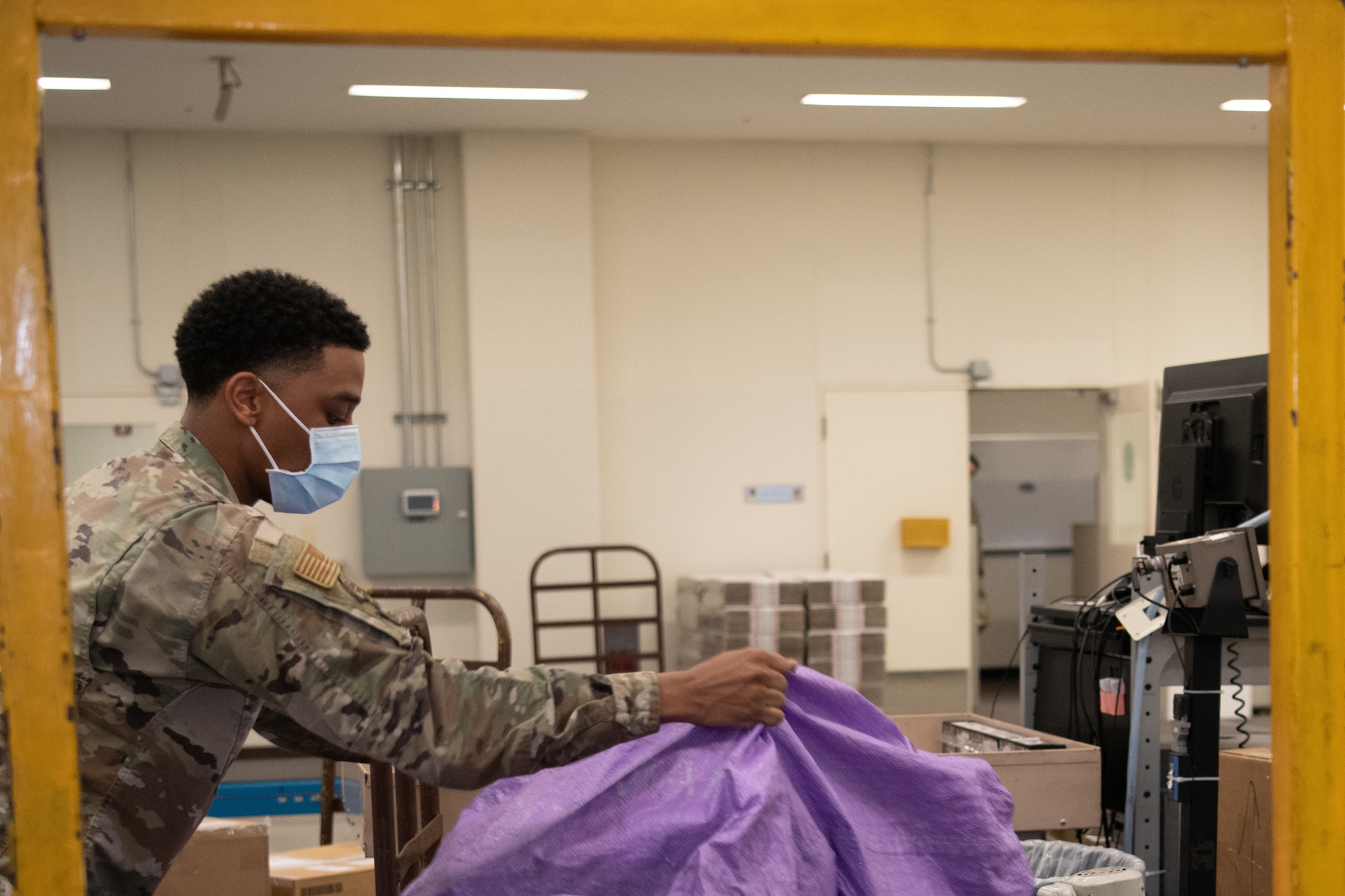 A mail processing clerk loads mail from conveyer belts