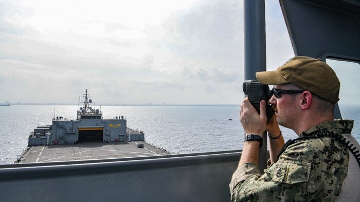Chief Master-at-Arms Adam Thorman uses a range finder to track approaching vessels as the expeditionary sea base USS Hershel "Woody" Williams (ESB 4) enters Dar es Salaam, Tanzania for a scheduled port visit, Dec. 22, 2022.
