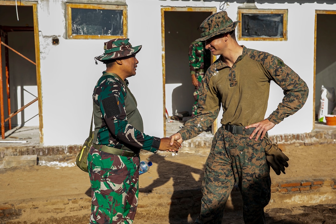 SUMBERWARU, INDONESIA (Dec. 15, 2022) - U.S. Marine Corps Cpl. Jonathan Natividad, an automotive maintenance technician with Combat Logistics Battalion 13, 13th Marine Expeditionary Unit, shakes hands with an Indonesian Korps Marinir before an Engineering Civic Assistance Project during Cooperation Afloat Readiness and Training/ Marine Exercise, Dec. 15, 2022.  CARAT/MAREX Indonesia is a bilateral exercise between Indonesia and the United States designed to promote regional security cooperation, maintain and strengthen maritime partnerships, and enhance maritime interoperability. In its 28th year, the CARAT series is comprised of multinational exercises, designed to enhance U.S. and partner navies’ and marine corps abilities to operate together in response to traditional and non-traditional maritime security challenges in the Indo-Pacific region.