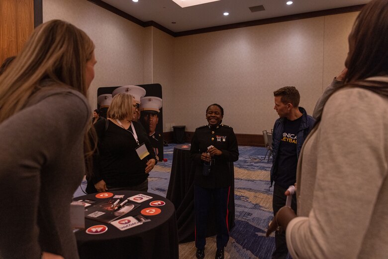 U.S. Marine Corps 2nd Lt. Dennielle Howes, air defense control officer, Marine Air Control Squadron 2, Marine Air Control Group 28, a native of Cleveland, Ohio, interacts with coaches at the 2022 WeCOACH Breakthrough Summit in Omaha, Nebraska. The partnership with WeCOACH offers the chance to connect Marines to influencers in order to build relationships that convert those influencers into advocates who can be relied on to support local recruiting activity. (U.S. Marine Corps photo by Lance Cpl. Gustavo Romero)