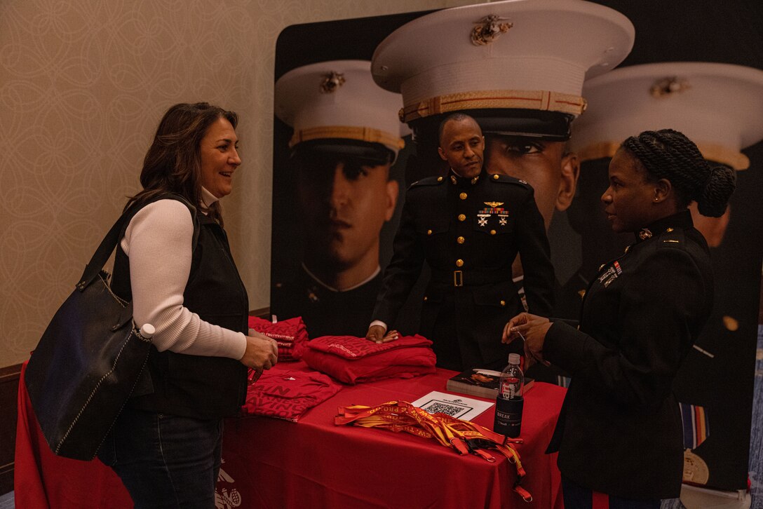 U.S. Marine Corps 2nd Lt. Dennielle Howes, air defense control officer, Marine Air Control Squadron 2, Marine Air Control Group 28, a native of Cleveland, Ohio, and Capt. Aaron Webster, national partnership officer, Marine Corps Recruiting Command, interacts with coaches at the 2022 WeCOACH Breakthrough Summit in Omaha, Nebraska. The partnership with WeCOACH offers the chance to connect Marines to influencers in order to build relationships that convert those influencers into advocates who can be relied on to support local recruiting activity. (U.S. Marine Corps photo by Lance Cpl. Gustavo Romero)