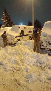 New York Army National Guard Soldiers assigned to the 827th Engineer Company and Airmen assigned to the 174th Attack Wing clear snow to recover an ambulance in Buffalo, N.Y., Dec. 26, 2022. The New York National Guard deployed 460 Soldiers to western New York to help transport health care workers and patients, clear roads and assist local authorities following the Christmas weekend snowstorm.