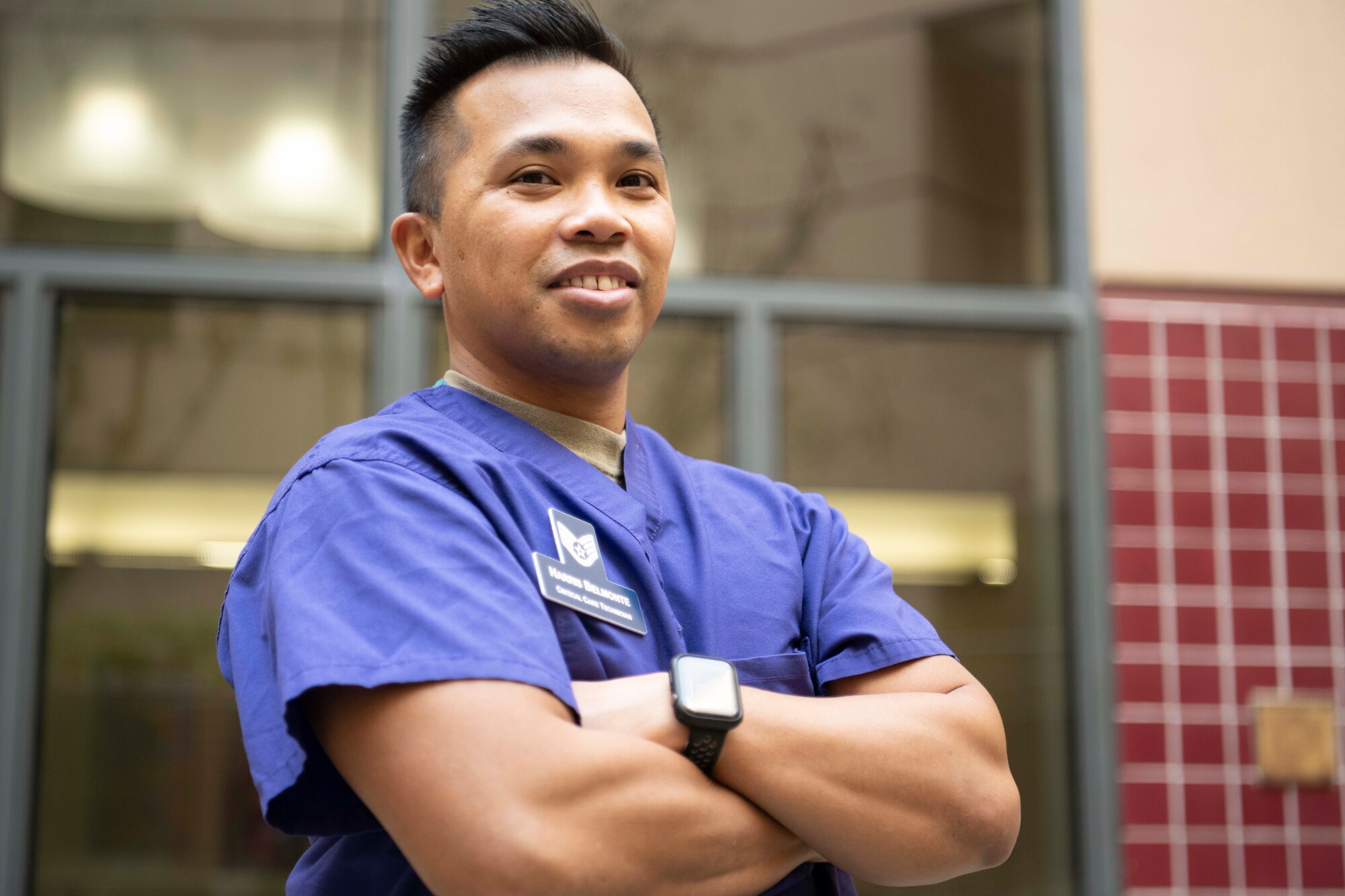 An Airman poses for a photo outside of a hospital.