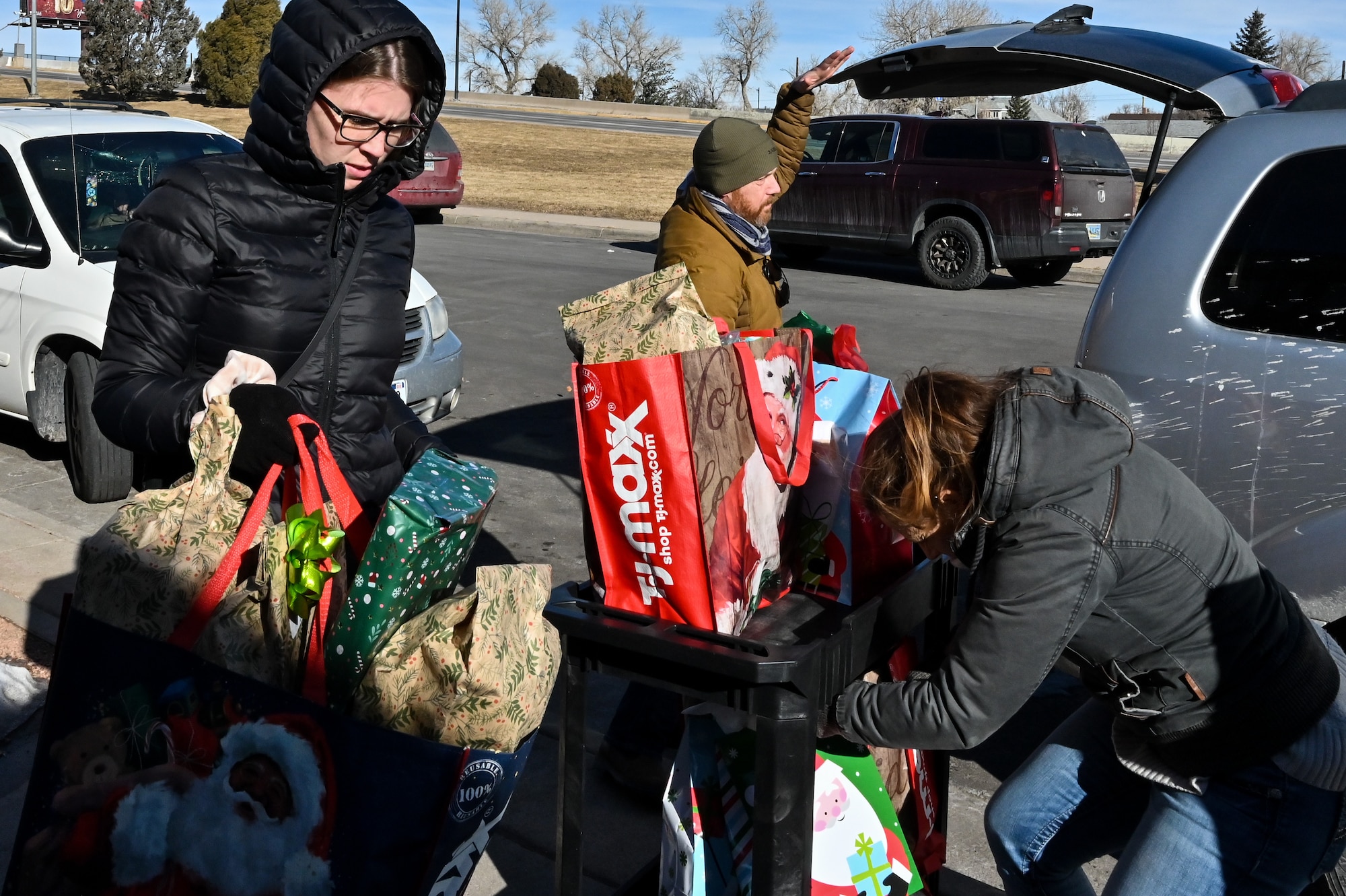 Senior Airman Kyra Blystone, 90 CONS contracting officer, puts presents on a cart to drop them off for local families in need as part of Needs Inc.’s Adopt a Family Program in Cheyenne, Wyoming, Dec 19, 2022. 90 CONS came together for the second consecutive year to support two families in need, so they did not have to choose between giving their kids food or celebrating the holiday season. (U.S. Air Force photo by Joseph Coslett Jr.)