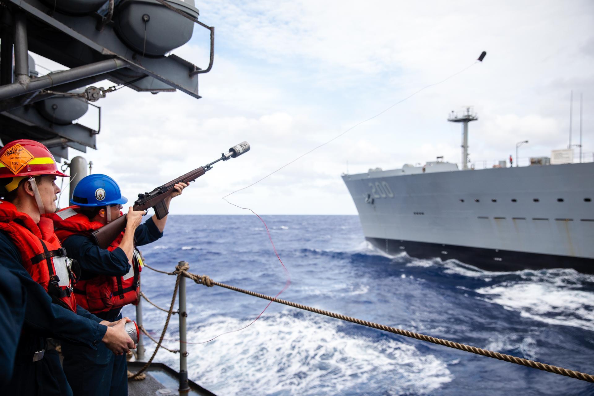 U.S. Navy Gunner's Mate 2nd Class Noah Rau, from Foley, Minn., fires a shot line from the Ticonderoga-class guided-missile cruiser USS Bunker Hill (CG 52) to the Henry J. Kaiser-class fleet replenishment oiler USNS Guadalupe (T-AO 200) during a replenishment-at-sea. Bunker Hill, part of the Nimitz Carrier Strike Group, is currently underway in 7th Fleet conducting routine operations.
