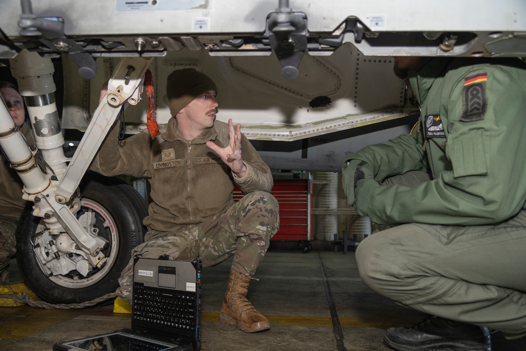 Airman trains German Luftwaffe member by an F-16.