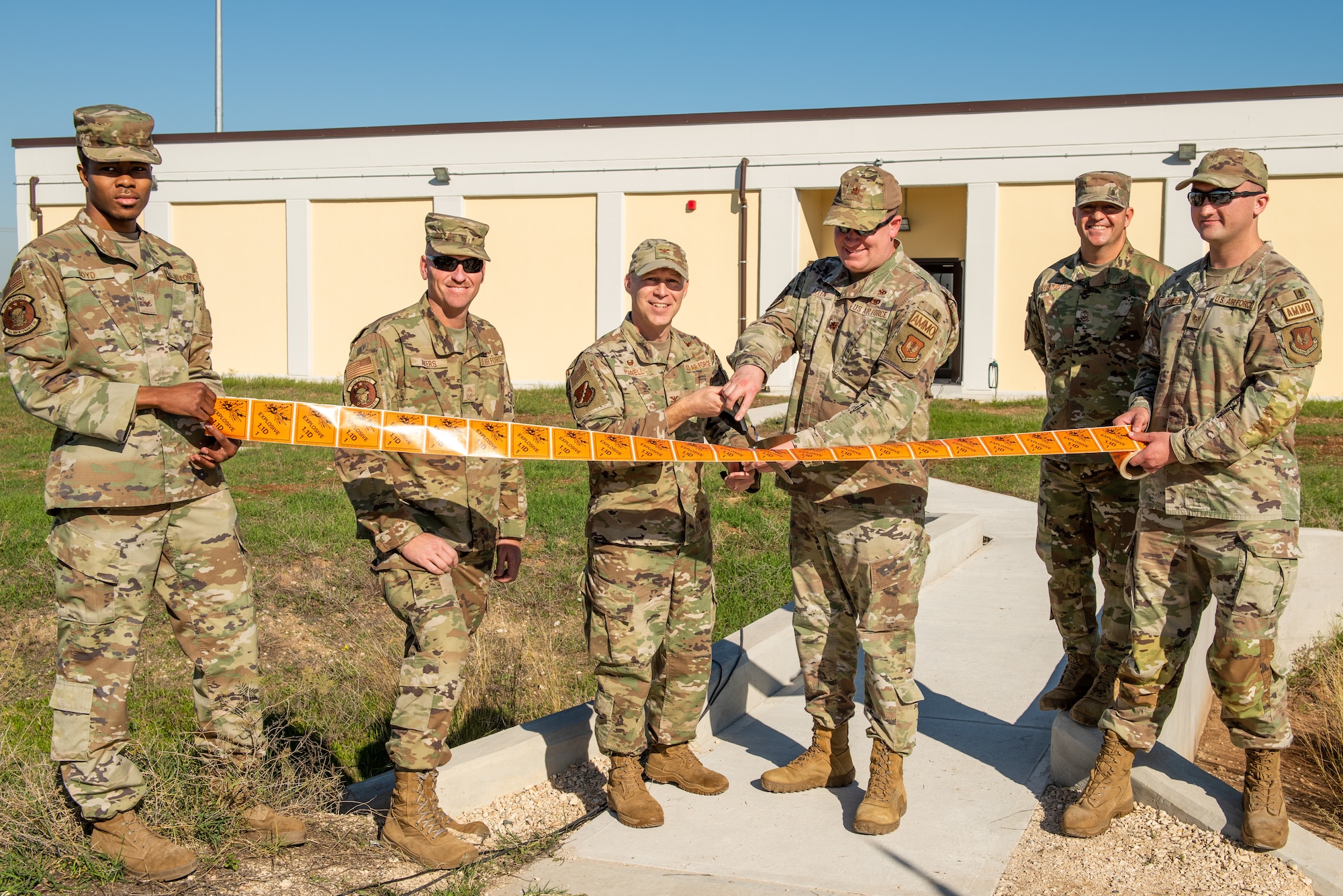 Col. Calvin Powell, 39th Air Base Wing commander, center left, and Maj. Jeffrey Allen, 39th Maintenance Squadron commander, center right, cut the ribbon during the 39th MXS munitions flight building dedication ceremony at Incirlik Air Base, Türkiye, Dec. 19, 2022. The 39th MXS munitions flight building was designed to provide a streamlined means of communication within the ammunitions flight and assist Airmen in building camaraderie and teamwork. The building also provides better protection for munitions assets controlled by the flight and consolidates six sections into a single building, increasing productivity for current and future Airmen. (U.S. Air Force photo by Senior Airman David D. McLoney)