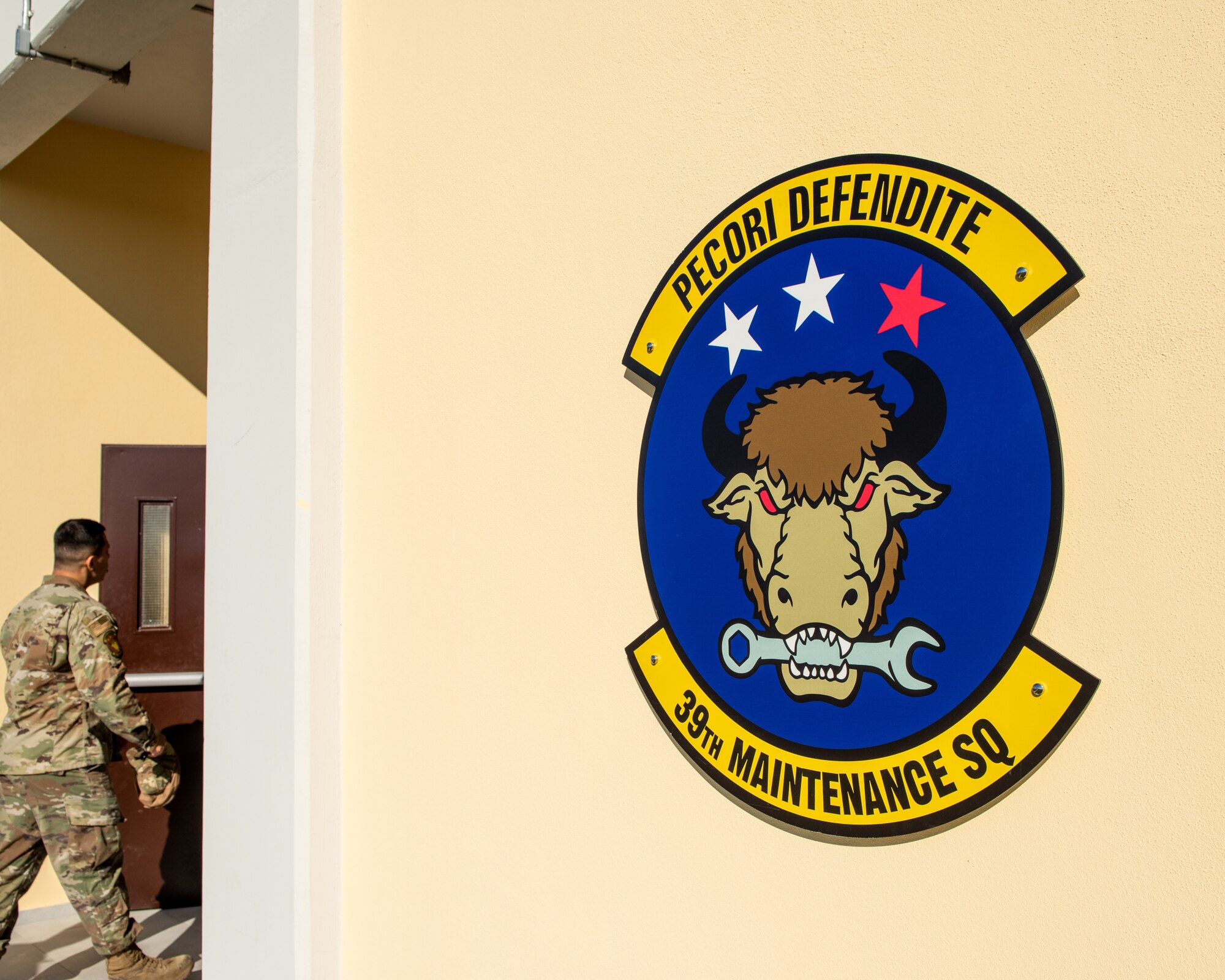 The 39th Maintenance Squadron emblem is displayed on the new munitions flight building at Incirlik Air Base, Türkiye, Dec. 19, 2022. Col. Calvin Powell, 39th Air Base Wing commander, and Maj. Jeffrey Allen, 39th Maintenance Squadron commander, presided over a ceremony to officially open the new 39th MXS munitions flight building, which was designed to provide a streamlined means of communication within the ammunitions flight and assist Airmen in building camaraderie and teamwork. The building also provides better protection for munitions assets controlled by the flight and consolidates six sections into a single building, increasing productivity for current and future Airmen. (U.S. Air Force photo by Senior Airman David D. McLoney)