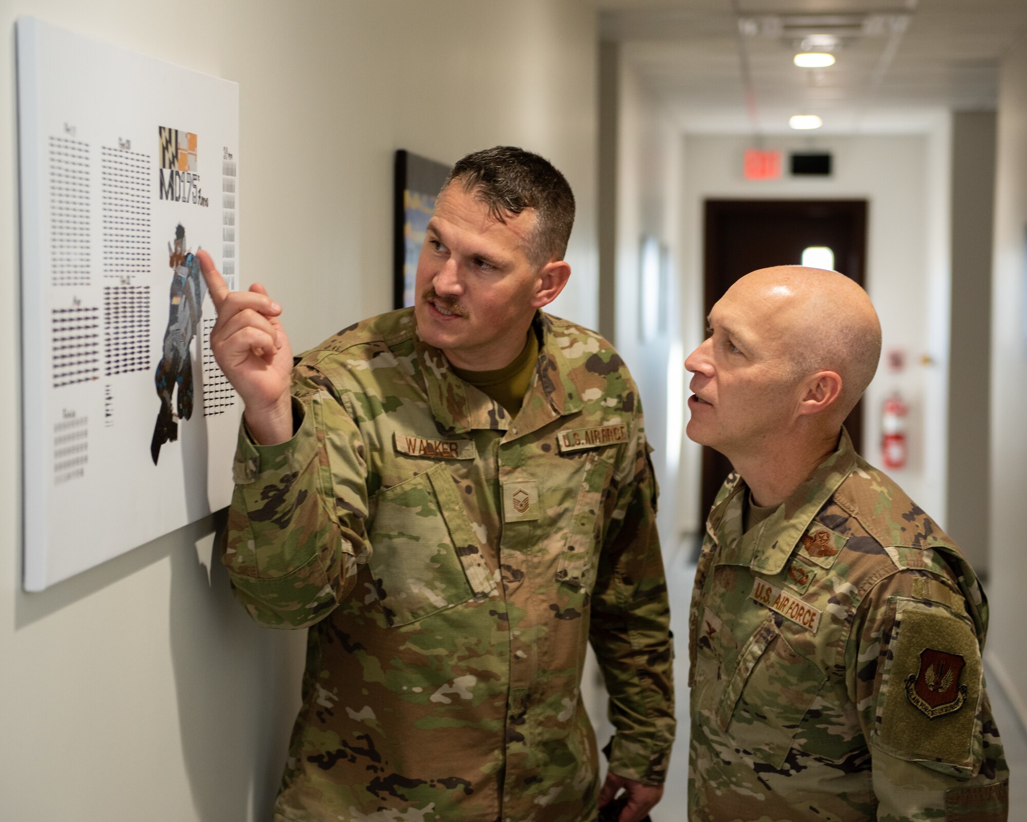 Master Sgt. Wesley Walker, 39th Maintenance Squadron munitions materiel flight chief, shows Col. Calvin Powell, 39th Air Base Wing commander, a newly printed graphic after the 39th MXS munitions flight building dedication ceremony at Incirlik Air Base, Türkiye, Dec. 19, 2022. The 39th MXS munitions flight building was designed to provide a streamlined means of communication within the ammunitions flight and assist Airmen in building camaraderie and teamwork. The building also provides better protection for munitions assets controlled by the flight and consolidates six sections into a single building, increasing productivity for current and future Airmen. (U.S. Air Force photo by Senior Airman David D. McLoney)