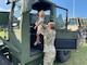 11th Transportation Battalion’s Sgt. Eric Hubbard lifts Remington Kniper up into the 10K ATLAS All-Terrain Vehicle during Joint Expeditionary Base Little Creek-Fort Story’s National Night Out event, Aug. 2. Installation and community partners handed out pamphlets and give-a-ways to attendees. National Night Out is a widespread event that encourages positive relationships between law enforcement agencies and their communities.