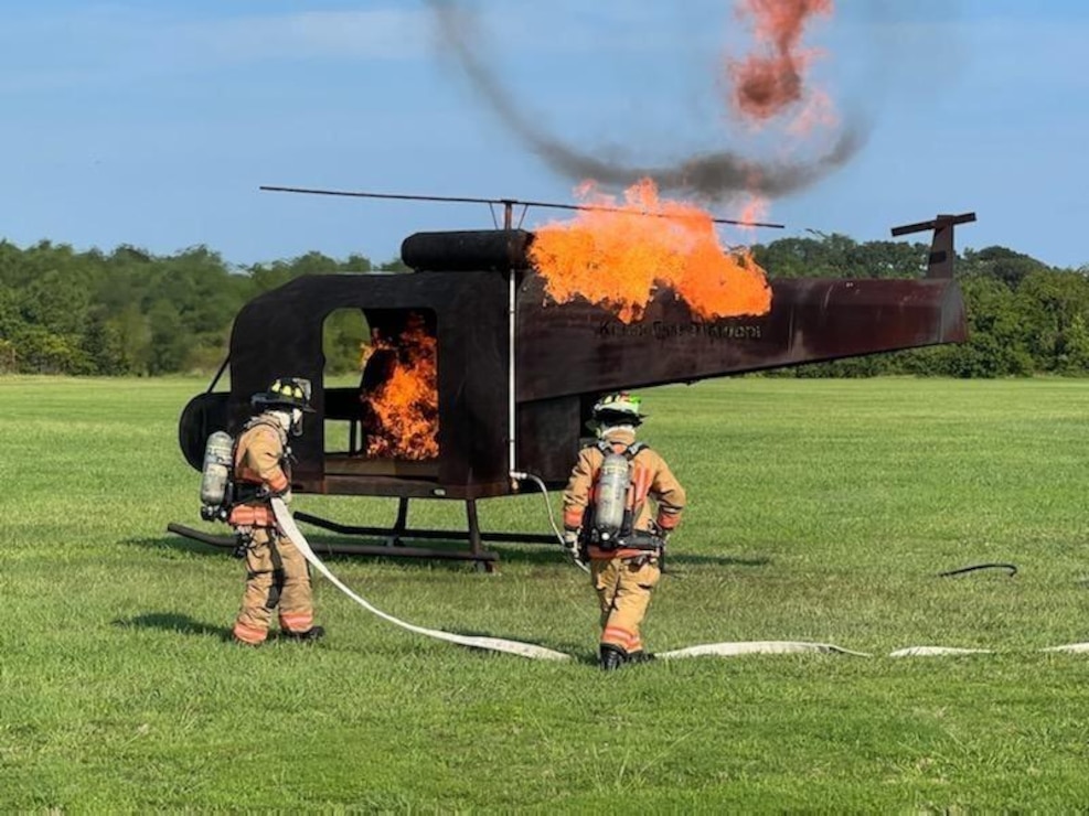 Navy Region Mid-Atlantic Fire & Emergency Services Firemen Taylor Harrington and Dakota Sawyer extinguish a helicopter crash fire during a training exercise held 2 Aug. at Joint Expeditionary Base Little Creek-Fort Story. The crash exercise is one of many exercises conducted annually. Diligent training between all partners enabled a quick and effective emergency response to the incident.