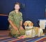 Cmdr. Tracey Krauss, officer in charge (OIC) and public health specialty Leader at Navy Medicine Readiness and Training Unit (NMRTU) Norfolk, sits on the floor alongside "Patty Mac", a facilities dog, often referred to as a stress dog, during a Professional Development (PRODEV) training at Joint Expeditionary Base Little Creek Fort Story (JEBLCFS) today. (U.S. Navy photo by Mass Communication Specialist 1st Class Marlon Goodchild)