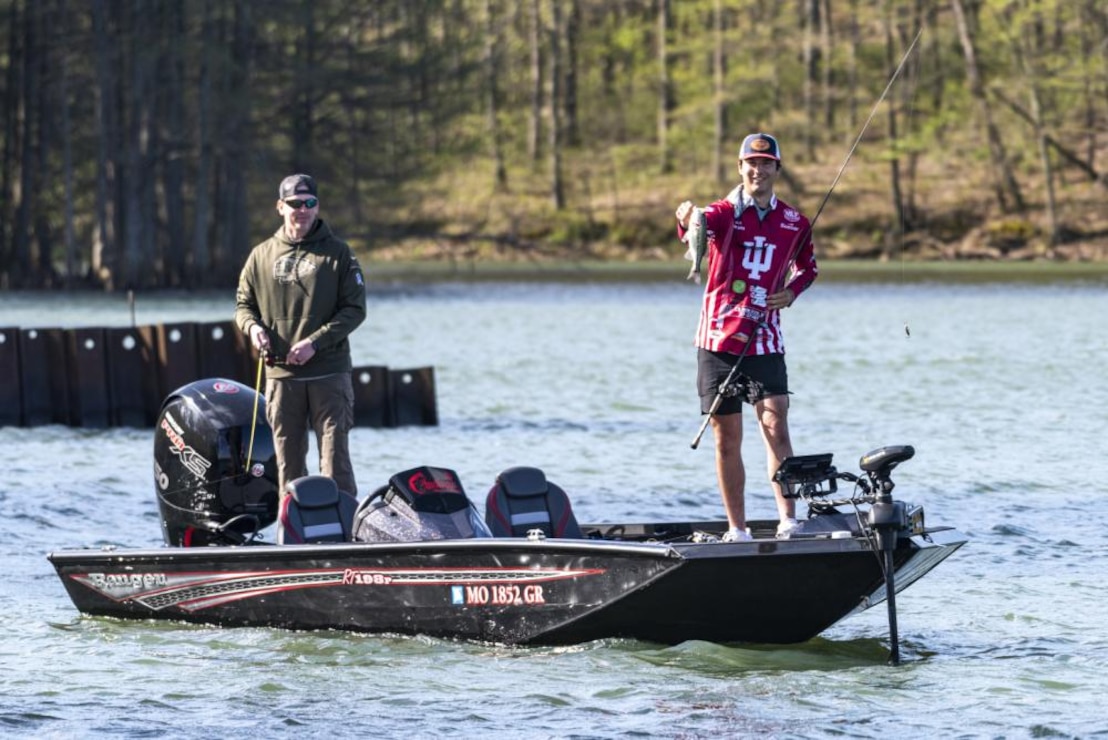 Indiana University Senior Andrew Yazdi (right) shows off his catch during a fishing tournament on Naval Support Activity Crane, May 1, 2022. Yazdi, who originally hails from St. Louis, Mo., graduates this spring, making this one of his last tournaments with the IU fishing club. His partner, Navy Lt. Cmdr. Luke Rayfield (left), commanding officer, Indianapolis Military Entrance Processing Station, won the contest with the biggest bass of the day. The event paired IU and Purdue University students with service members from various commands throughout Indiana.
