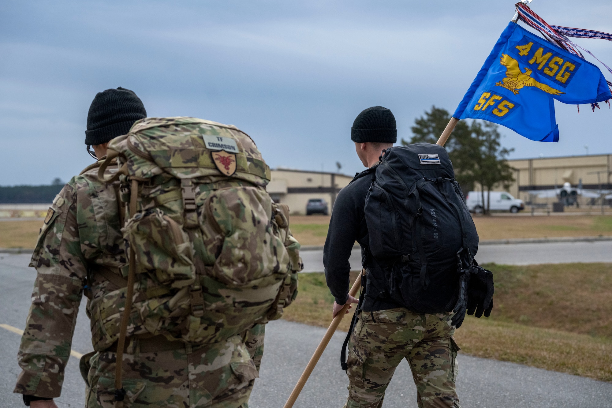 Airman 1st Class Jonathan Scott (right), 4th Security Forces Squadron installation entry controller, carries the 4th SFS guidon next to Master Sgt. Kyle Henderson, 4th SFS NCO in-charge of weapons and tactics, during a six-mile ruck at Seymour Johnson Air Force Base, North Carolina, Dec. 21, 2022. The ruck was in remembrance of those assigned to Task Force Crimson “Hustler 6” who lost their lives on Dec. 21, 2015 to a motorcyclist who detonated an improvised explosive device claiming the lives of four Air Force Office of Special Investigations agents and two Security Forces defenders. (U.S. Air Force photo by Senior Airman Kevin Holloway)