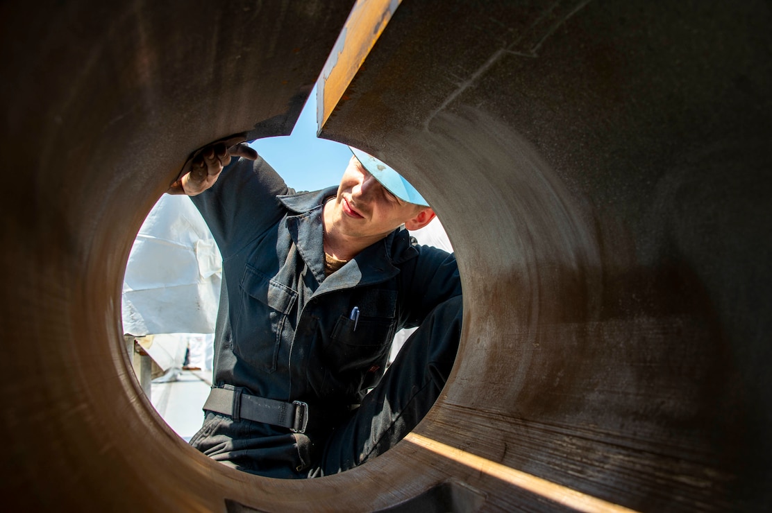 Airman Tyler Heston, from Fairfield, Iowa, sands a water brake cylinder aboard the Nimitz-class aircraft carrier USS Dwight D. Eisenhower (CVN 69). Ike is currently pierside at Norfolk Naval Shipyard in the basic phase of the optimized fleet response plan (OFRP).
