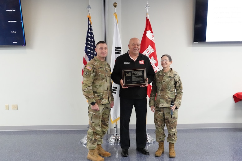 Stephen Brown, U.S. Army Corps of Engineers, Far East District (FED) Equal Employment Opportunity (EEO) manager, receives the 2021 Chief of Engineers Equal Employment Opportunity Award. Standing beside him are FED Commander, Col. Heather A. Levy (right), and U.S. Army Corps of Engineers Pacific Ocean Division Command Sgt. Maj. Douglas W. Galick. (U.S. Army photo by Far East District)