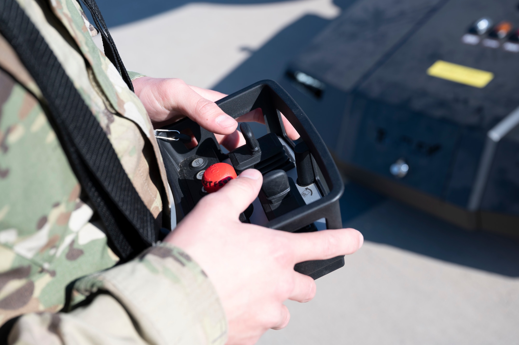 An Airman from the 29th Aircraft Maintenance Unit uses a remote control to maneuver a TowFLEXX TF3 aircraft tug at Holloman Air Force Base, New Mexico, Dec. 15, 2022. The TF3’s radio remote control has a high-range signal which allows Airmen to maneuver it from all sides. (U.S. Air Force photo by Airman 1st Class Isaiah Pedrazzini)