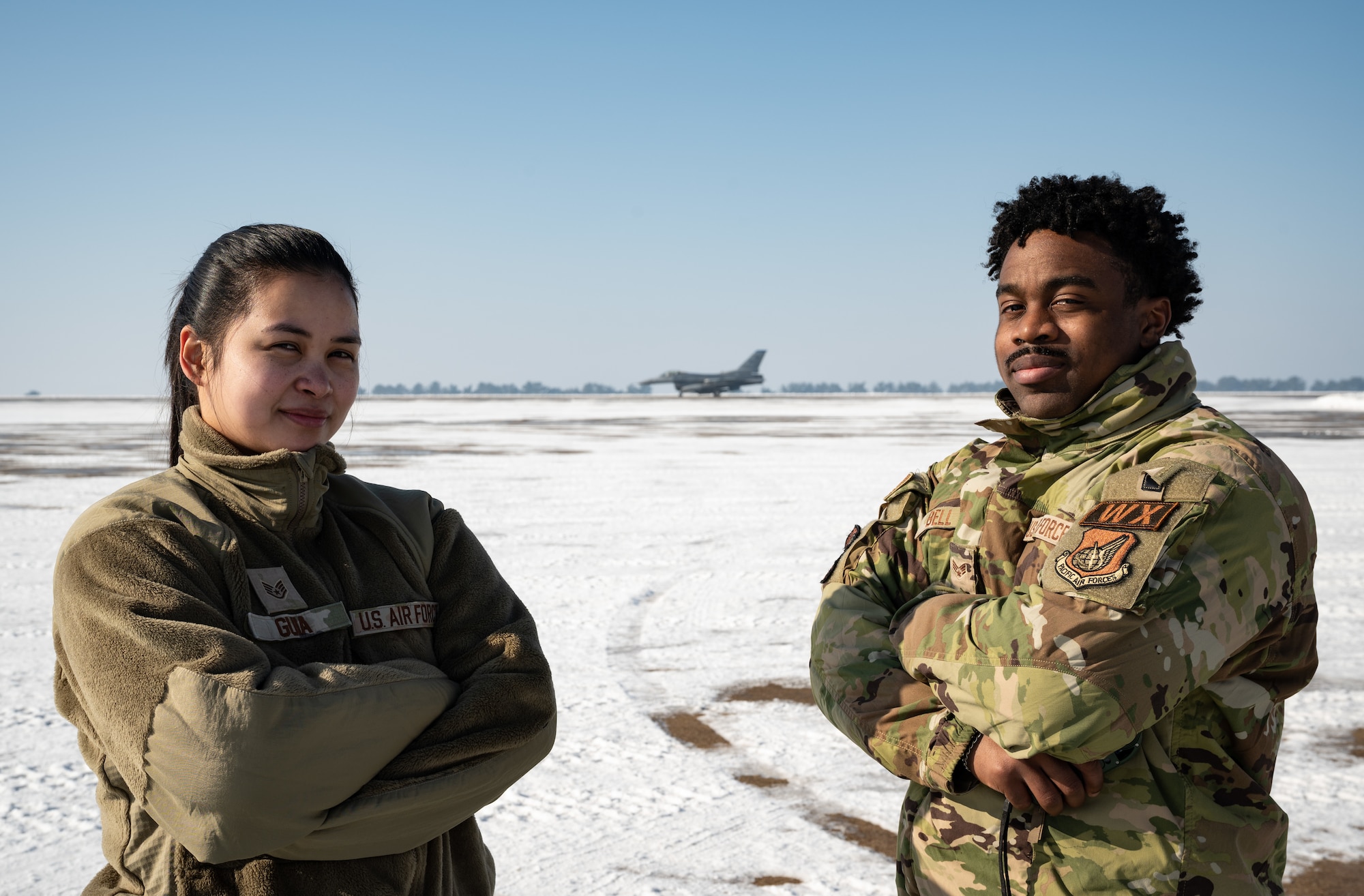 Staff Sgt. Reza Guia (left), and Senior Airman Patrick Bell, both 8th Operations Support Squadron weather forecasters, stand for a photo at Kunsan Air Base, Republic of Korea, Dec. 2022. Kunsan’s weather flight informs leaders on weather conditions that could pose a safety threat to personnel and assets, arming them with knowledge to make calls on weather safety precautions. (U.S. Air Force photo by Staff Sgt. Sadie Colbert)